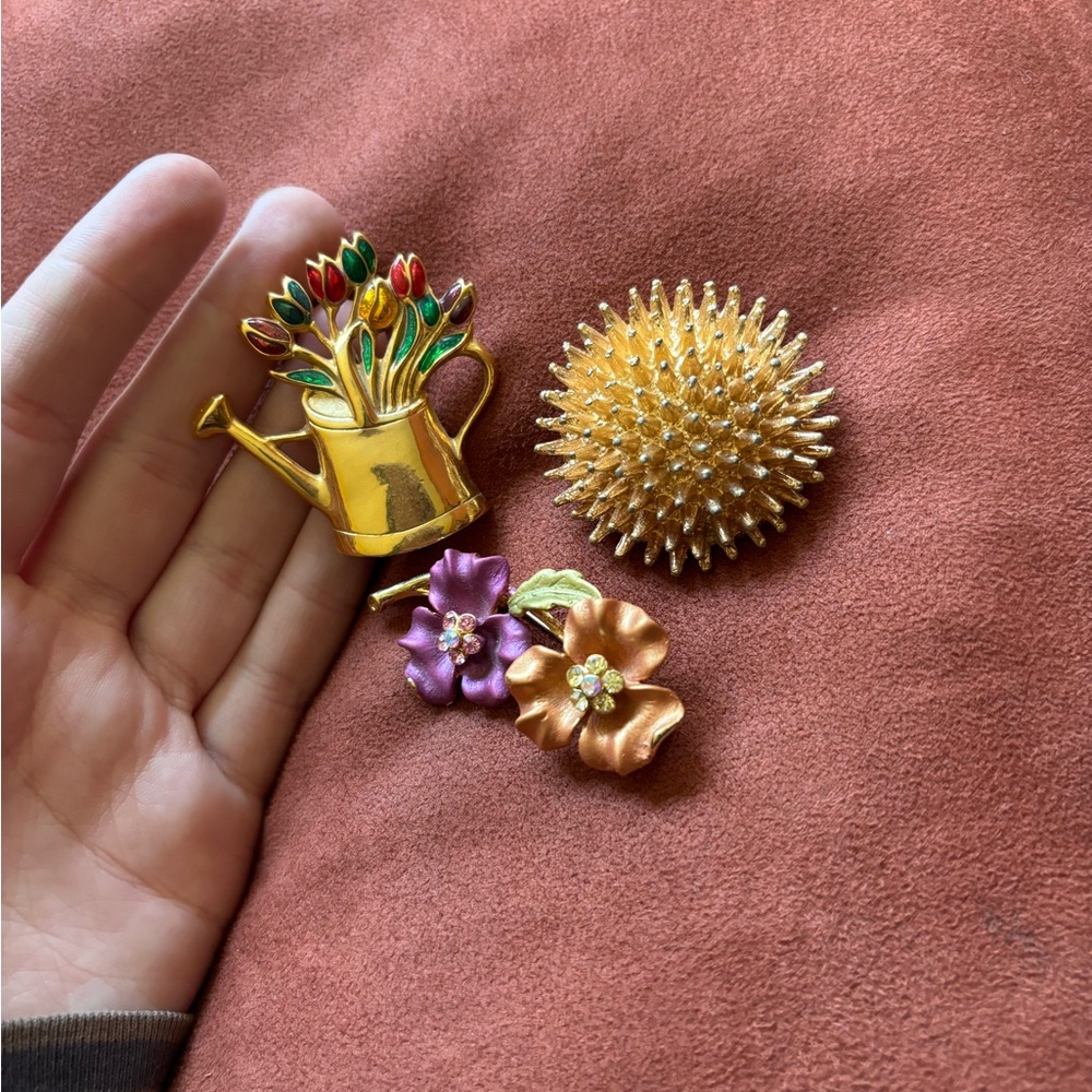 Three golden flower brooches